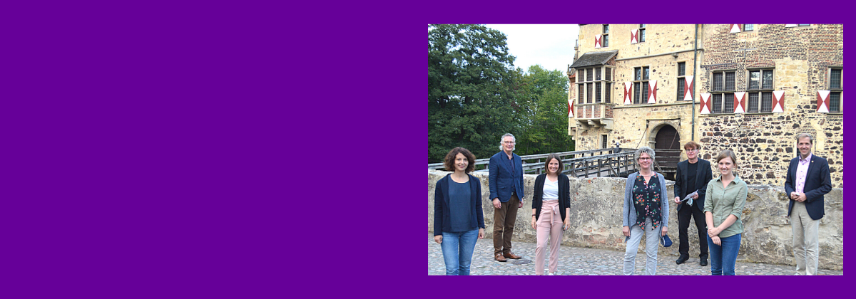 Das Veranstaltungsteam gemeinsam mit Landrat Dr. Christian Schulze-Pellengahr (rechts) und Sozialdeszernent des Kreises Detlef Schütt (links) auf dem Gelände der Burg Vischering in Lüdinghausen. 