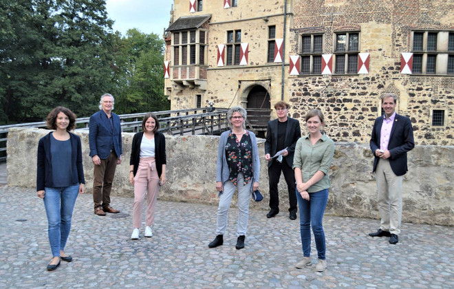 Das Veranstaltungsteam gemeinsam mit Landrat Dr. Christian Schulze-Pellengahr (rechts) und Sozialdeszernent des Kreises Detlef Schütt (links) auf dem Gelände der Burg Vischering in Lüdinghausen 