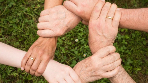 Hände die Handgelenke umfassen und einen Kreis bilden