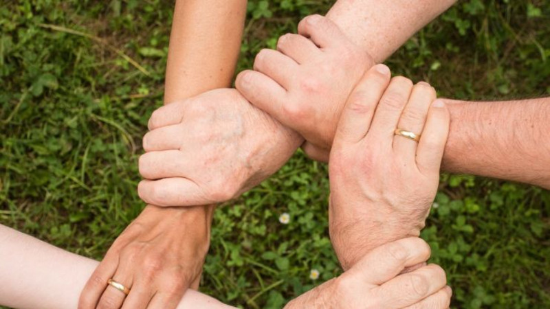 Hände die Handgelenke umfassen und einen Kreis bilden